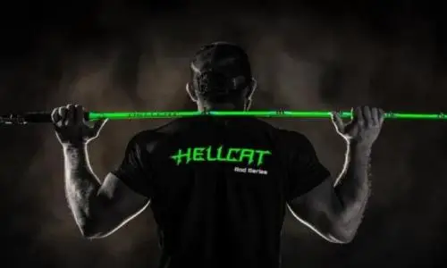 Angler holding a neon-green HellCat fishing rod from Catch The Fever in a dark studio setting.