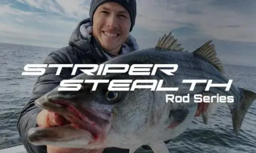 Smiling angler with a striped bass caught using a Striper Stealth rod from Catch The Fever on open water.