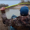 Spencer Bauer’s bright-green Hellcat rod bends sharply as he reels in a feisty winter catfish from his kayak.